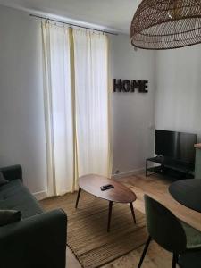 ein Wohnzimmer mit einem Sofa und einem Couchtisch in der Unterkunft Appartement moderne calme et spacieux-Centre Thuillat in Limoges