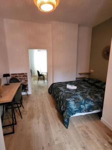Schlafzimmer mit einem Bett, einem Tisch und einem Schreibtisch in der Unterkunft Appartement moderne calme et spacieux-Centre Thuillat in Limoges