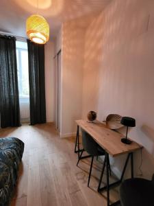 ein Wohnzimmer mit einem Tisch und einem Sofa in der Unterkunft Appartement moderne calme et spacieux-Centre Thuillat in Limoges