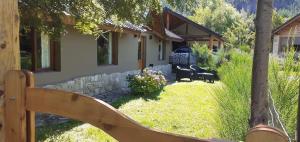 a house with a fence in front of a yard at Vuelvo al Sur Alojamiento Lago Puelo in Lago Puelo