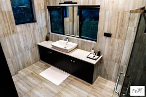 a bathroom with a sink and a mirror at Karawwa Luxury Villas in Hikkaduwa