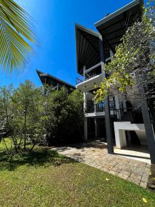 a view of a building with trees in front of it at Karawwa Luxury Villas in Hikkaduwa