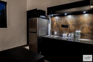uma cozinha com um frigorífico de aço inoxidável num quarto em Karawwa Luxury Villas em Hikkaduwa