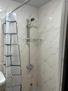 a bathroom with a shower with white marble tiles at Oldtown Apartments in Mtskheta
