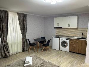 a kitchen with a washing machine and a table and chairs at Oldtown Apartments in Mtskheta