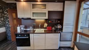 a small kitchen with white cabinets and a sink at Coffee Apartment in Varna City
