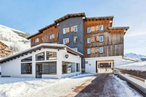 een groot gebouw met sneeuw op de grond bij HOTEL TURAN in Les Deux Alpes