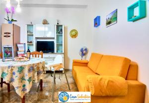 ein Wohnzimmer mit einem Sofa und einem Tisch in der Unterkunft CasaSalentina in Santa Maria al Bagno