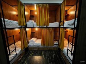 a room with two bunk beds with yellow curtains at Flats Hostel in Astana