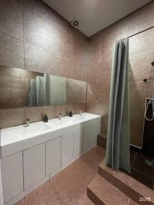 uma casa de banho com 2 lavatórios e um espelho grande em Flats Hostel em Astana