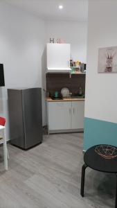 uma cozinha com um frigorífico, uma mesa e uma cadeira em Apartment Melograno5 em Catânia