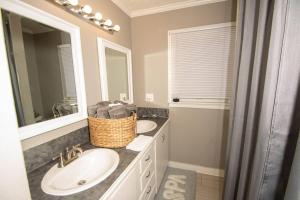 a bathroom with two sinks and a mirror at Home Sweet Home Bungalow in North Little Rock