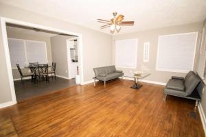 a living room with a ceiling fan and a wooden floor at Home Sweet Home Bungalow in North Little Rock