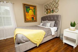 a bedroom with a bed with a yellow blanket on it at Midtown Serenity in Little Rock in Little Rock