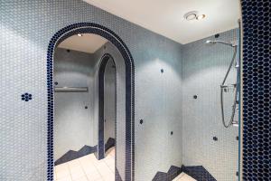 ein Bad mit einer Dusche und einem Spiegel in der Unterkunft Hotel Breitlehenalm in Obertauern