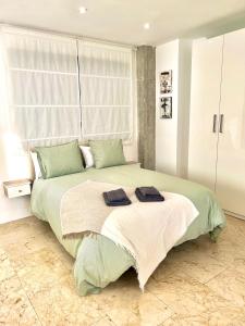 1 dormitorio con 1 cama grande y 2 toallas. en El patio de Cruz Conde en Córdoba