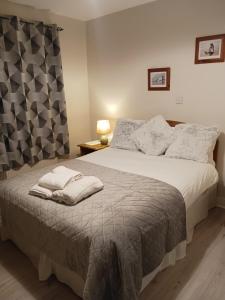 a bedroom with a large bed with a gray blanket at Johnny B's B&B in Ballybofey