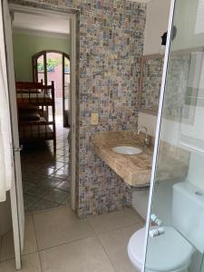 a bathroom with a sink and a toilet at Pousada Guarujá in Guarujá