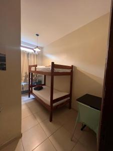a small room with a bunk bed and a table at Rio 222 Hostel in Rio de Janeiro