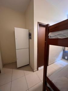 a small room with a bunk bed and a refrigerator at Rio 222 Hostel in Rio de Janeiro