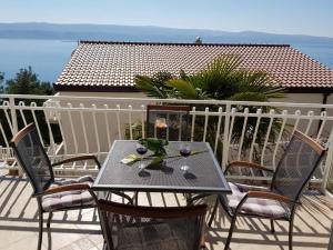 a table with wine glasses on top of a balcony at Apartmani ABA in Stanići