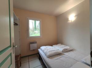 a small bedroom with a bed with a window at Gites 4,6 personnes Fécamp Etretat in Colleville