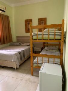 sypialnia z 2 łóżkami piętrowymi w pokoju w obiekcie Pousada Guarujá w mieście Guarujá