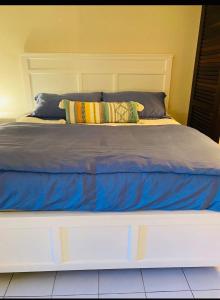 un grande letto con lenzuola e cuscini blu sopra di Sapphire Beach Resort and Marina a East End
