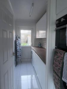 een kleine keuken met een aanrecht en een raam bij Home in Basildon, Essex in Basildon
