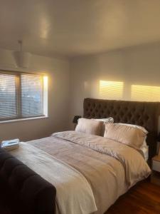 a bedroom with a large bed and two windows at Home in Basildon, Essex in Basildon