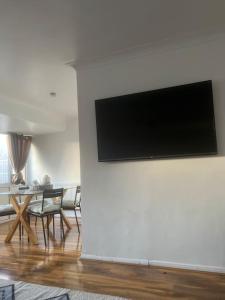 een woonkamer met een flatscreen-tv aan de muur bij Home in Basildon, Essex in Basildon