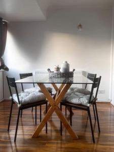 a dining room table with four chairs and a table with a table at Home in Basildon, Essex in Basildon