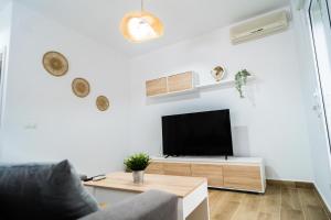 een woonkamer met een tv aan een witte muur bij Apartamento Patio Real in Ronda