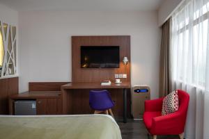 a hotel room with a bed and a desk and a tv at Campanile Xi'an Bell Tower Huimin Street in Xi'an