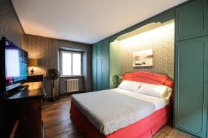 a bedroom with a bed and a flat screen tv at CASA VASCONI CERNOBBIO in Cernobbio
