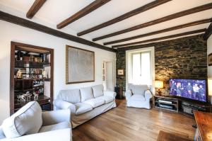 a living room with two white couches and a tv at CASA VASCONI CERNOBBIO in Cernobbio