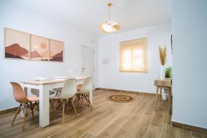 uma sala de jantar branca com uma mesa e cadeiras brancas em Apartamento Patio Real em Ronda