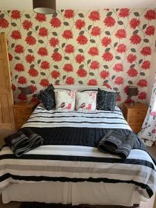 a bedroom with a bed with a floral wall at Snowberry Cottage No 2 in Onich