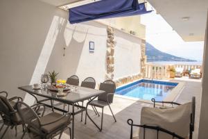 une salle à manger avec une table et des chaises ainsi qu'une piscine dans l'établissement Apartment Valentina - private pool,200m from beach, à Omiš