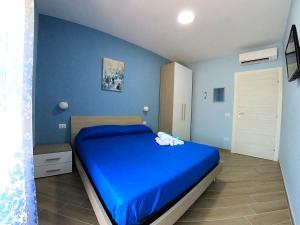 - une chambre bleue dotée d'un lit avec un mur bleu dans l'établissement B&B Il Gioiello, à Formia