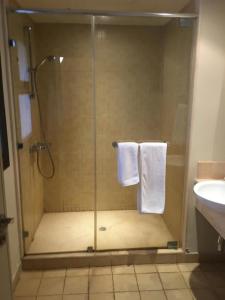 a bathroom with a shower with towels and a sink at Marina residence Chalet port ghalib in Port Ghalib