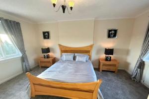 a bedroom with a wooden bed with two night stands at The Old High Road in Stevenston