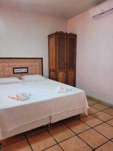 a bedroom with a bed with two towels on it at Pousada Villa Rosada in Santa Cruz Cabrália