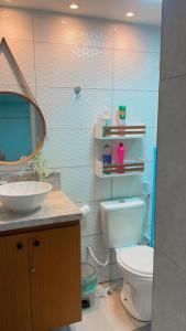 ein Badezimmer mit Toilette, Waschbecken und Spiegel in der Unterkunft HOME SERVICE MAR & SOL in Porto De Galinhas