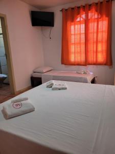 Una cama o camas en una habitación de Pousada Villa Rosada