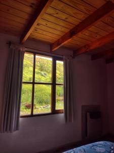 a bedroom with a window with a view of a field at Casa Pircas in El Chalten