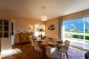 a dining room with a table and chairs and a large window at Entre lac et montagnes in Doussard
