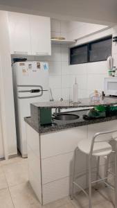 eine weiße Küche mit Spüle und Kühlschrank in der Unterkunft HOME SERVICE MAR & SOL in Porto De Galinhas