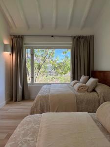 a bedroom with two beds and a large window at Victorias Villas in Villa de Leyva