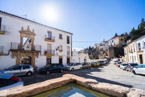 una calle con coches estacionados en un estacionamiento en Apartamento Patio Real, en Ronda